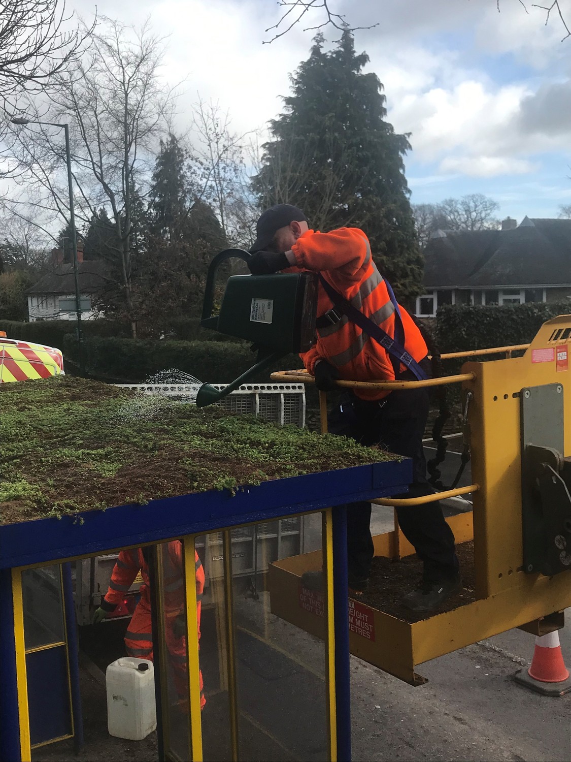 Town Council staff watering the new sedum roof on a bus shelter at Radbrook Road